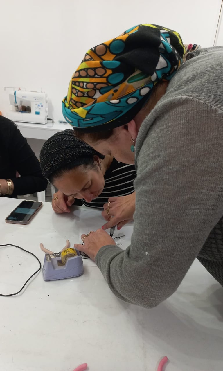 An instructor helping a participant with metal line artwork