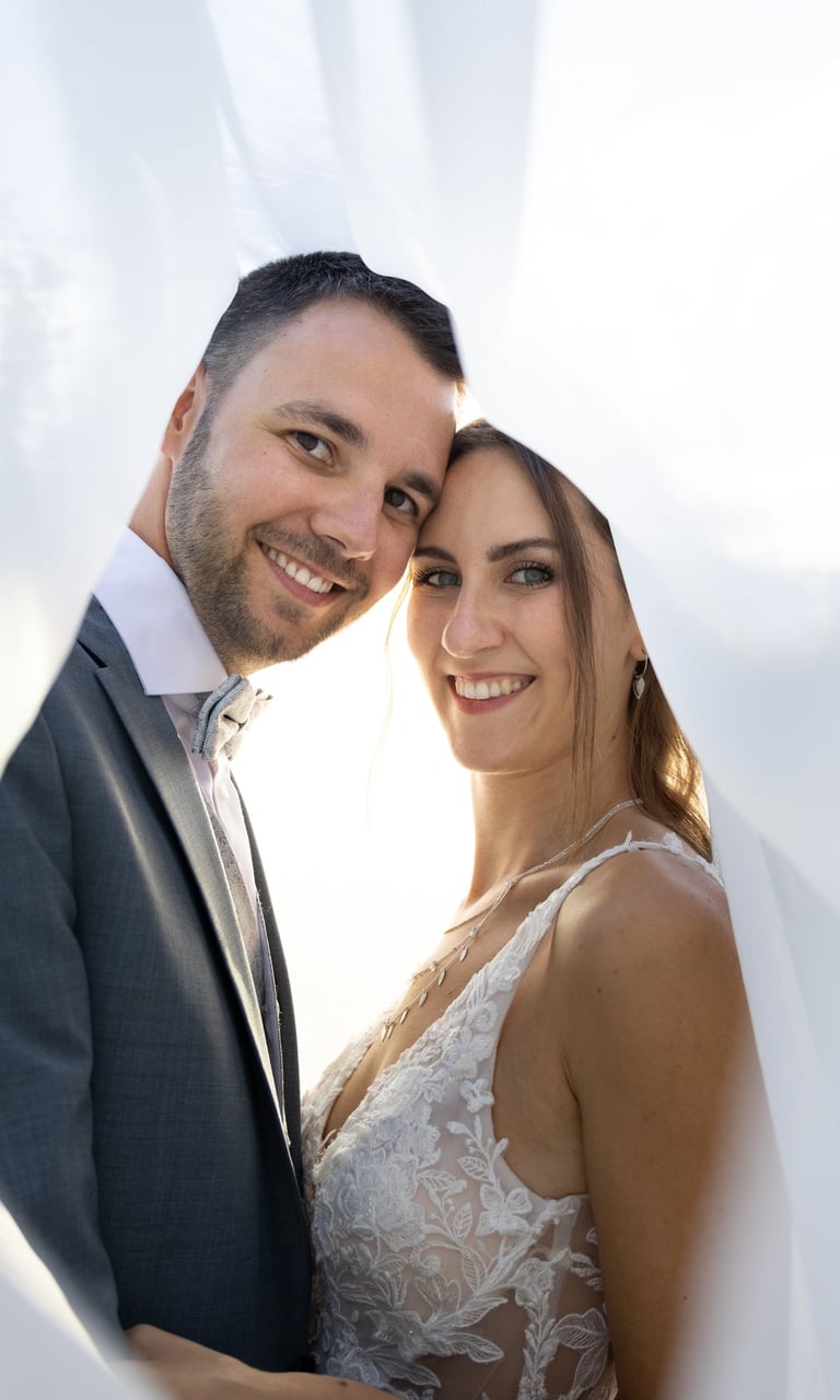 Kreative Hochzeitsfotografie Coburg: Romantisches Brautpaar im Sonnenlicht unter dem Schleier.