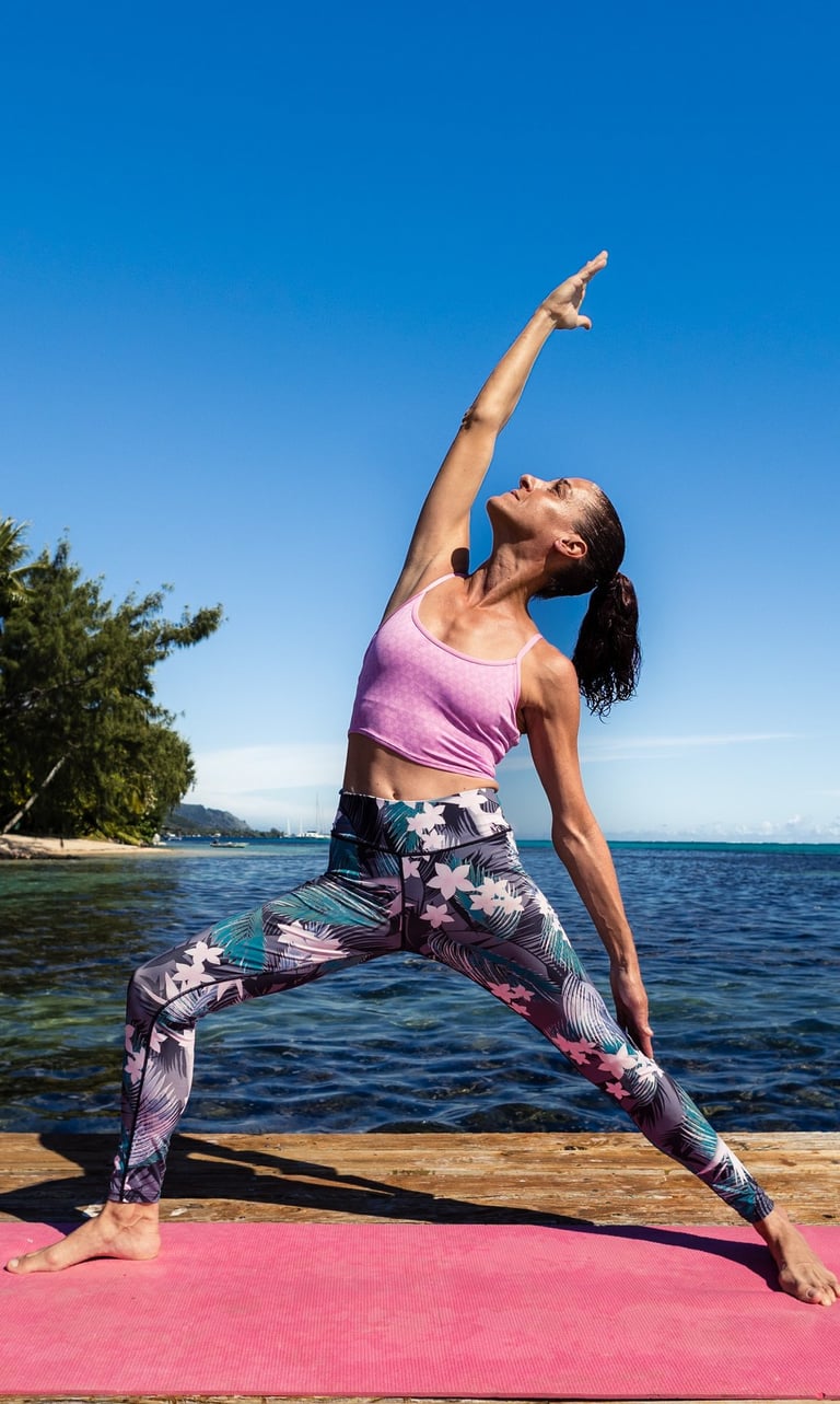 a woman in a pink top and leggings doing yoga