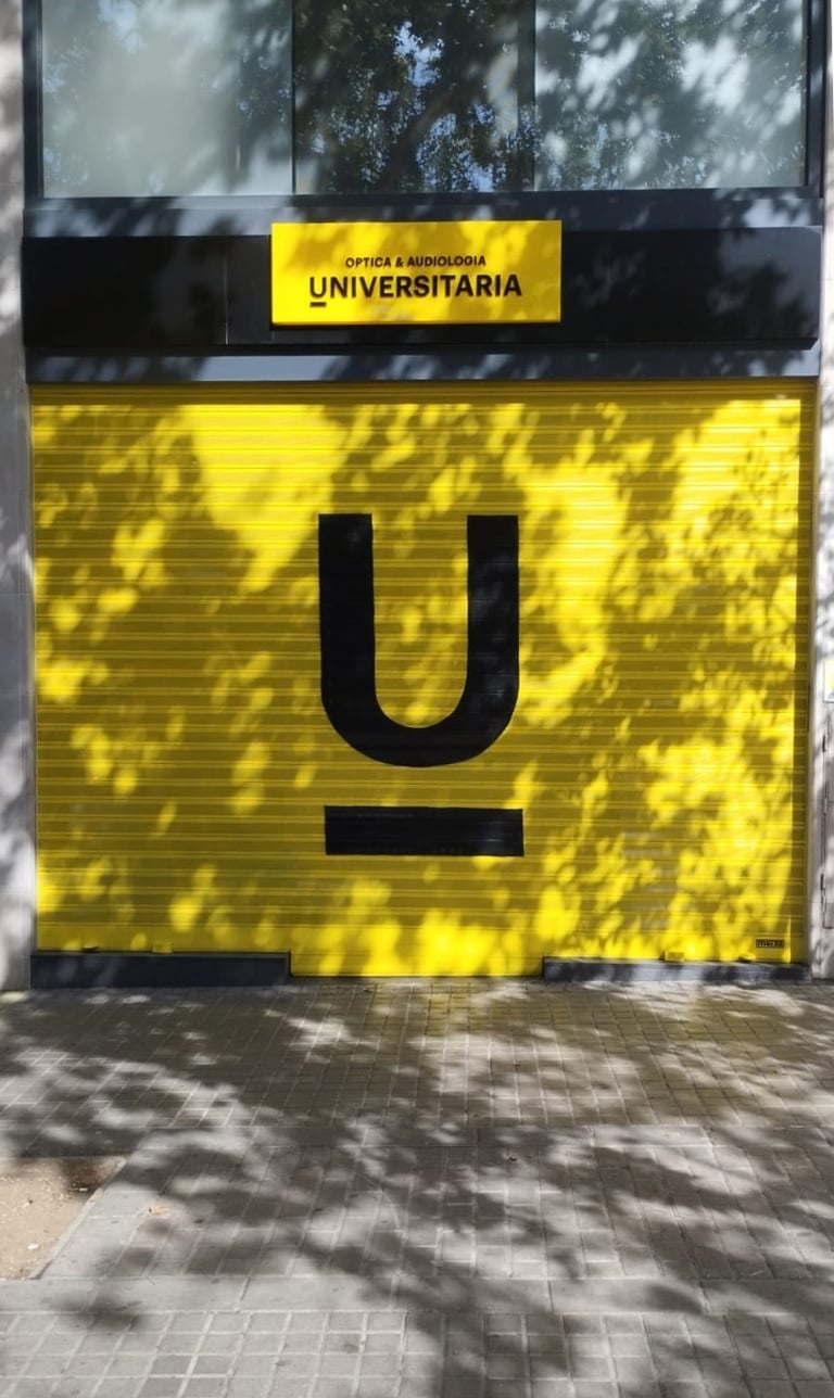 Graffiti en persiana, cierre metálico de Óptica Universitaria, Barcelona