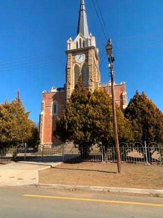a church steeple with a clock tower in the background