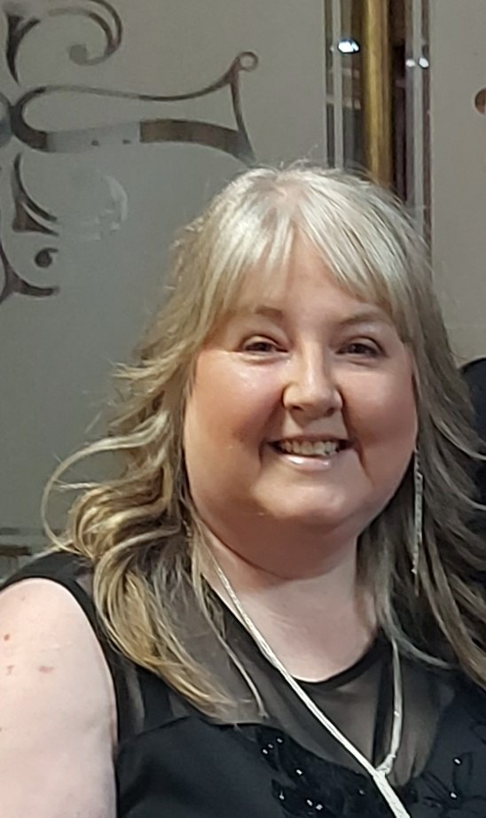 A picture of Jan Wilson wearing a black dress with a beaded neckline.