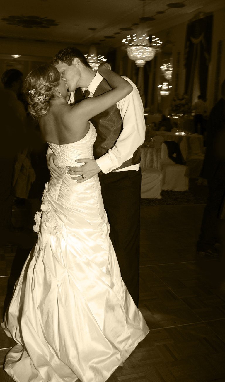 a bride and groom dancing and kissing at their wedding reception in a hotel ball room