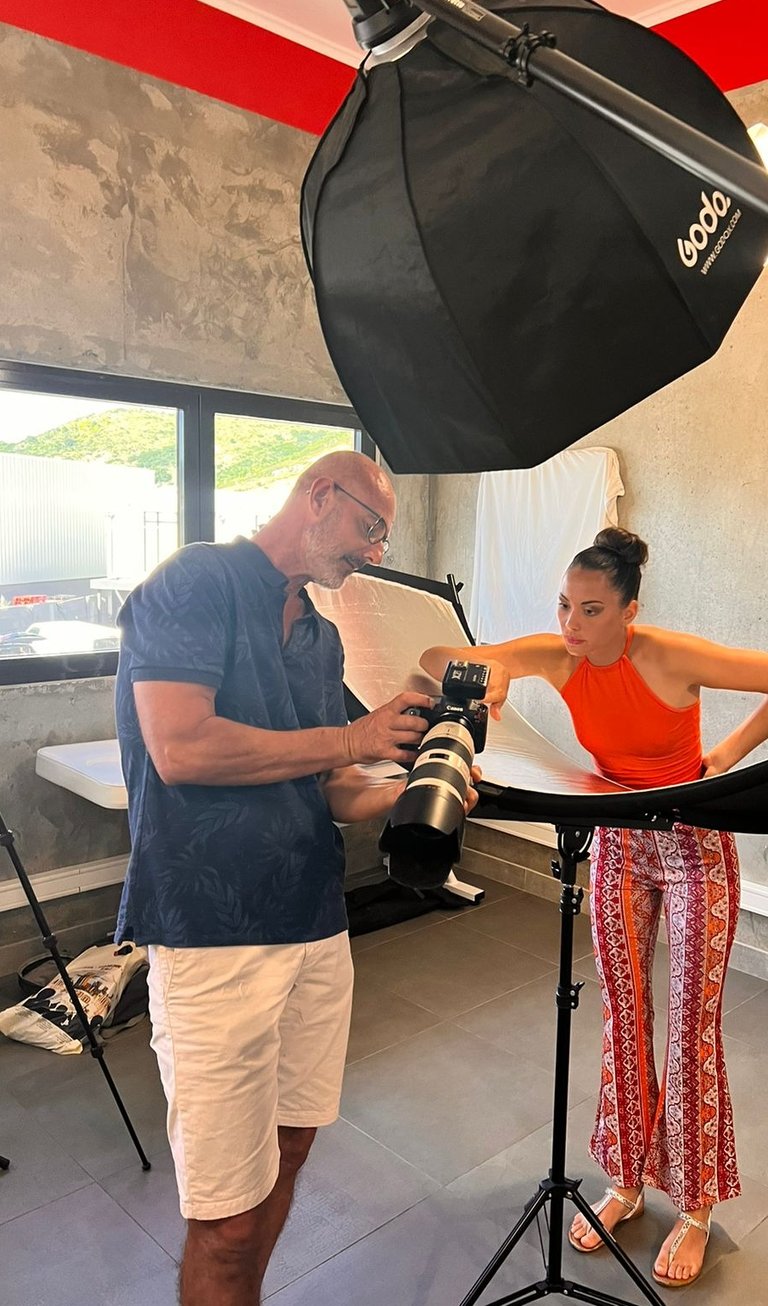Portrait photographer sharing recent shots with the model during a studio session