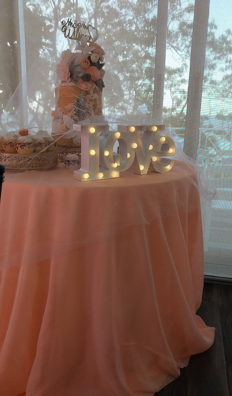a table with a table cloth and a cake and a love sign