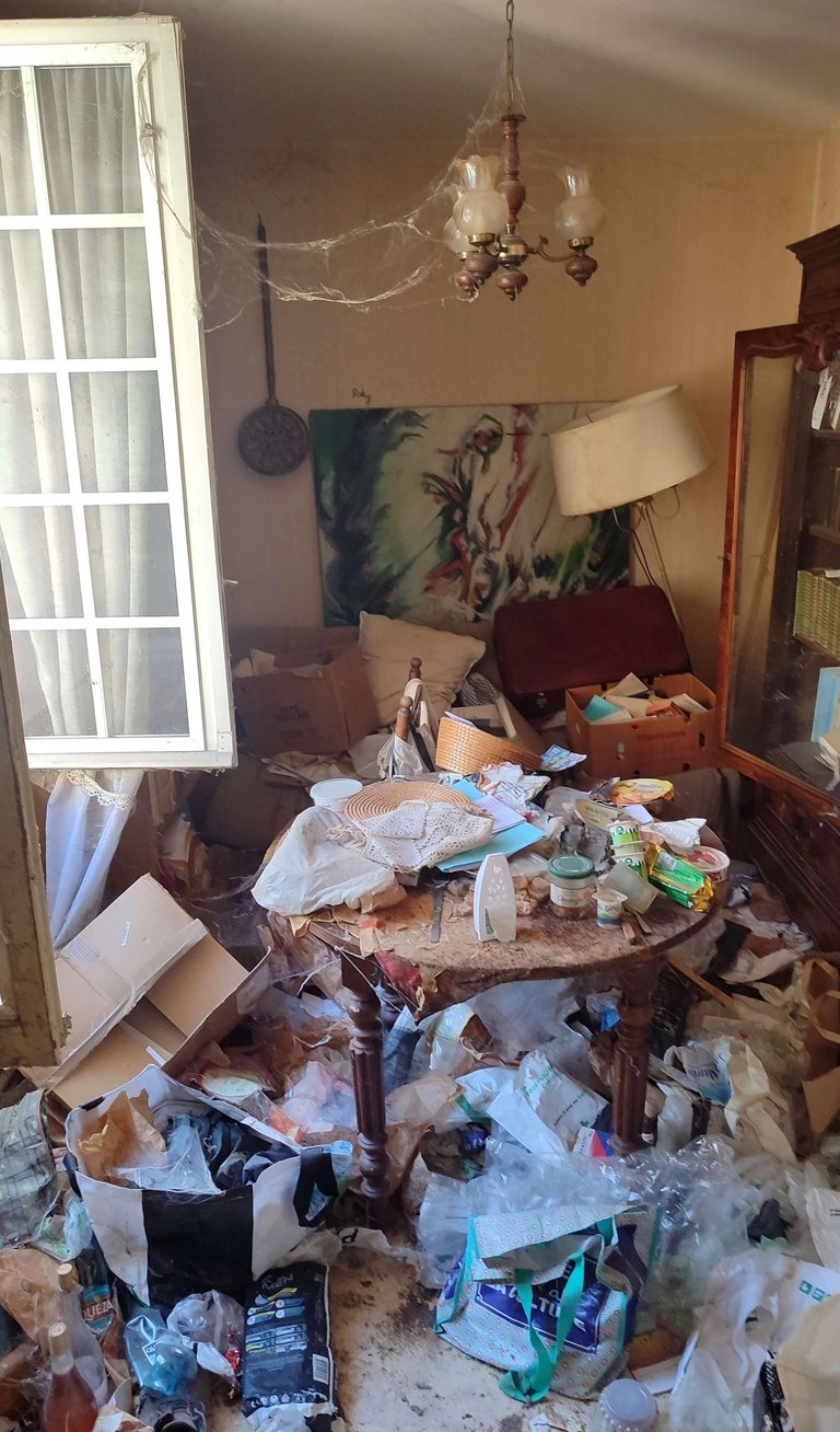 Débarras Lepeltier - Une pièce encombrée, avec des vêtements, des livres et des objets éparpillés partout.