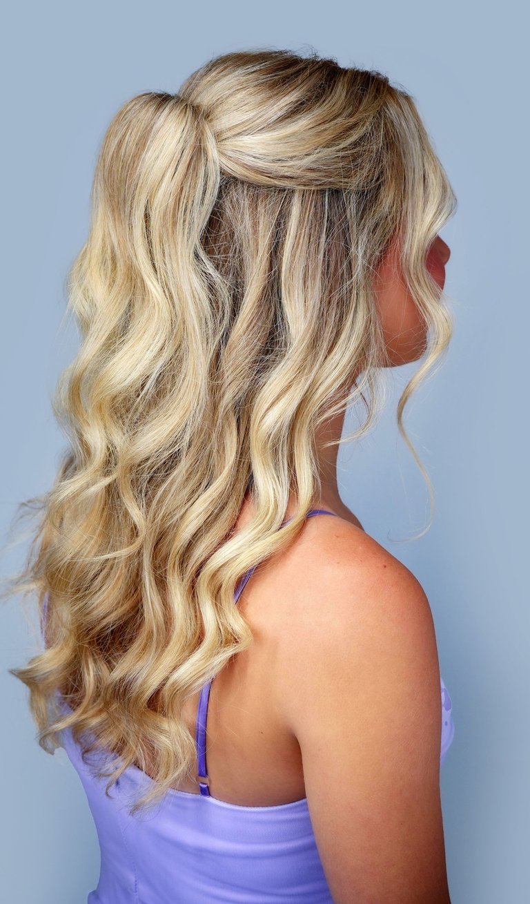 Bride with blonde hair styled in half-up glam waves, polished curls, and volume, perfect for wedding hair and makeup.