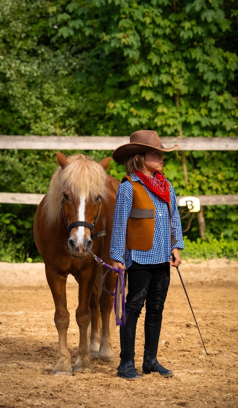 a boy in a cowboy hat and a horse