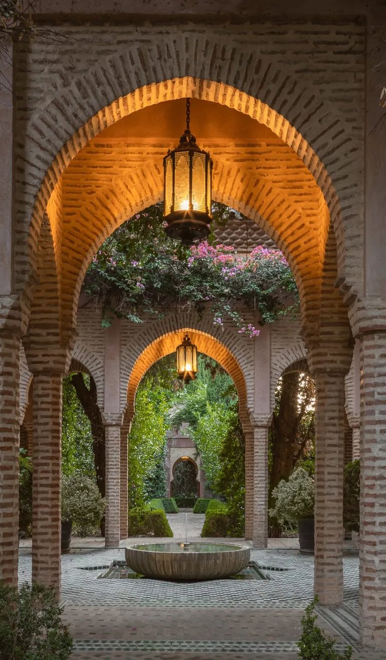 Lantern-lit Moorish colonnade with tiled floor and inner fountain