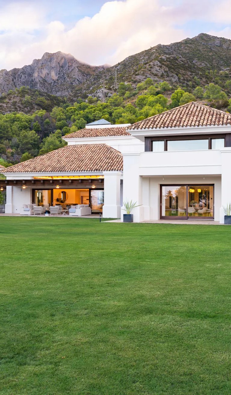 Rear façade with expansive lawn and mountain backdrop