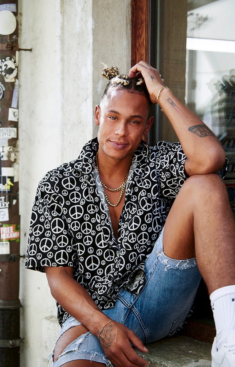 a man sitting on a ledge with a peace sign