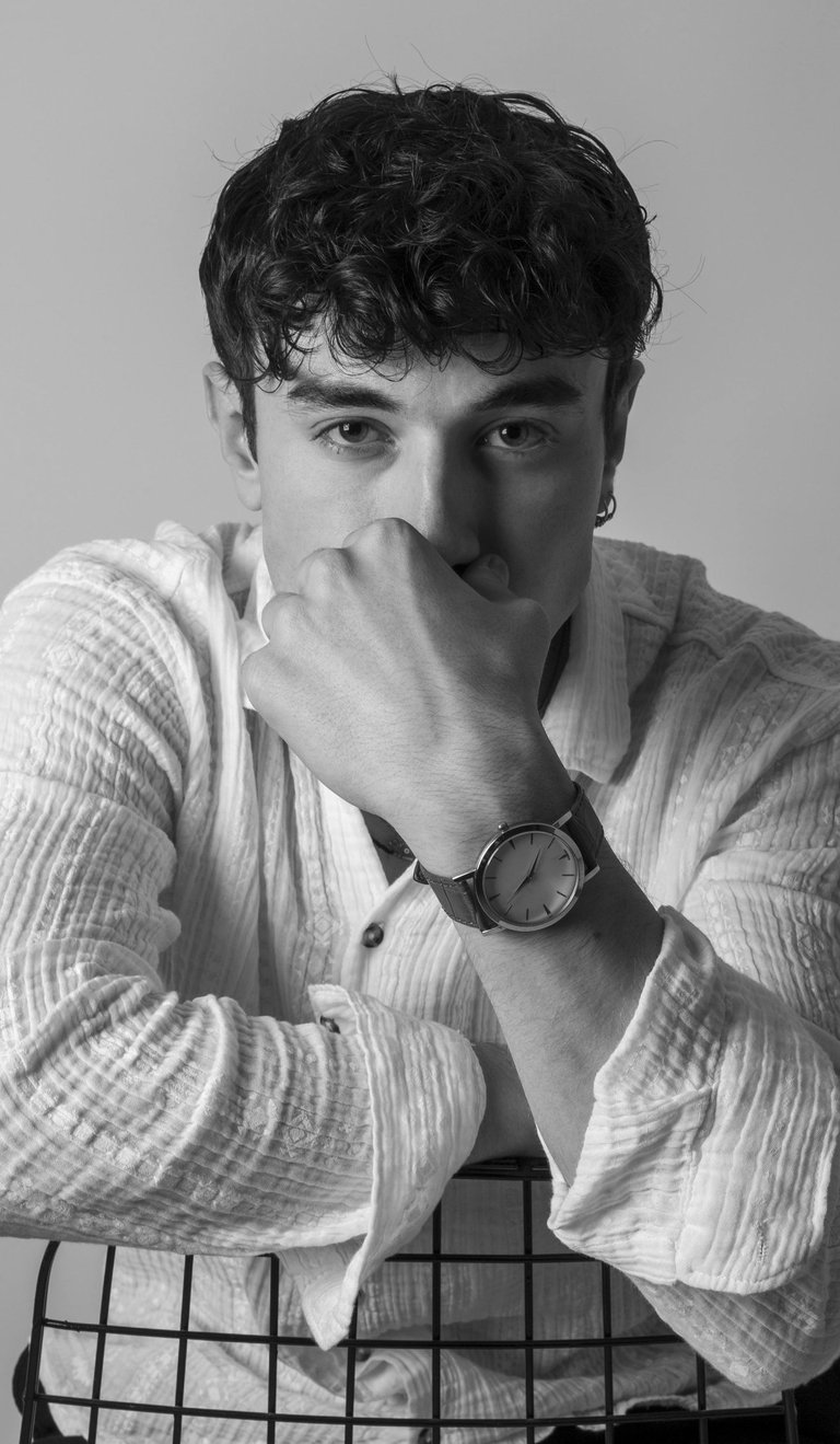 a man sitting in a chair with his hands on his chin