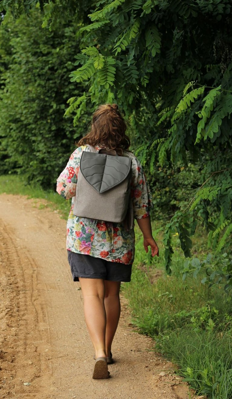 a woman walking with a handmade vegan backpack