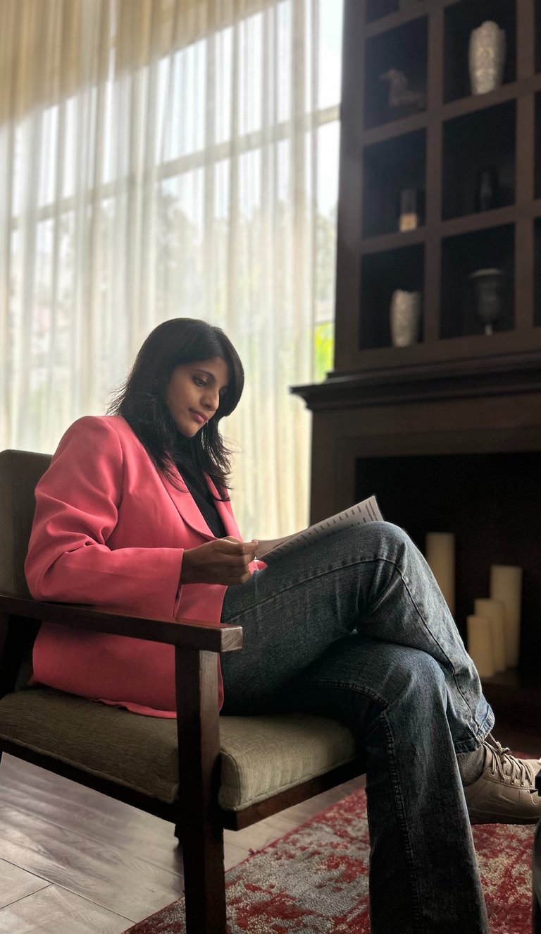 a woman sitting in a chair with a bookcase