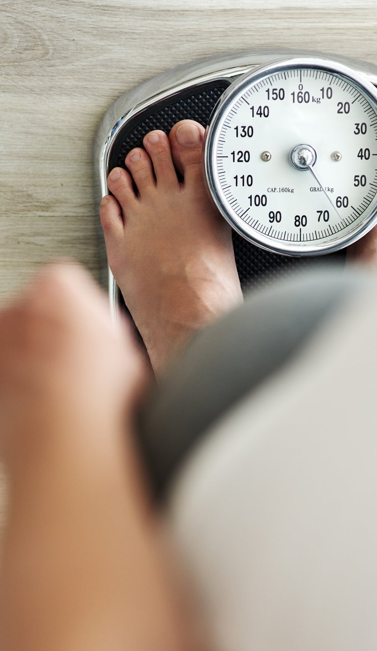 Persona pesándose en báscula