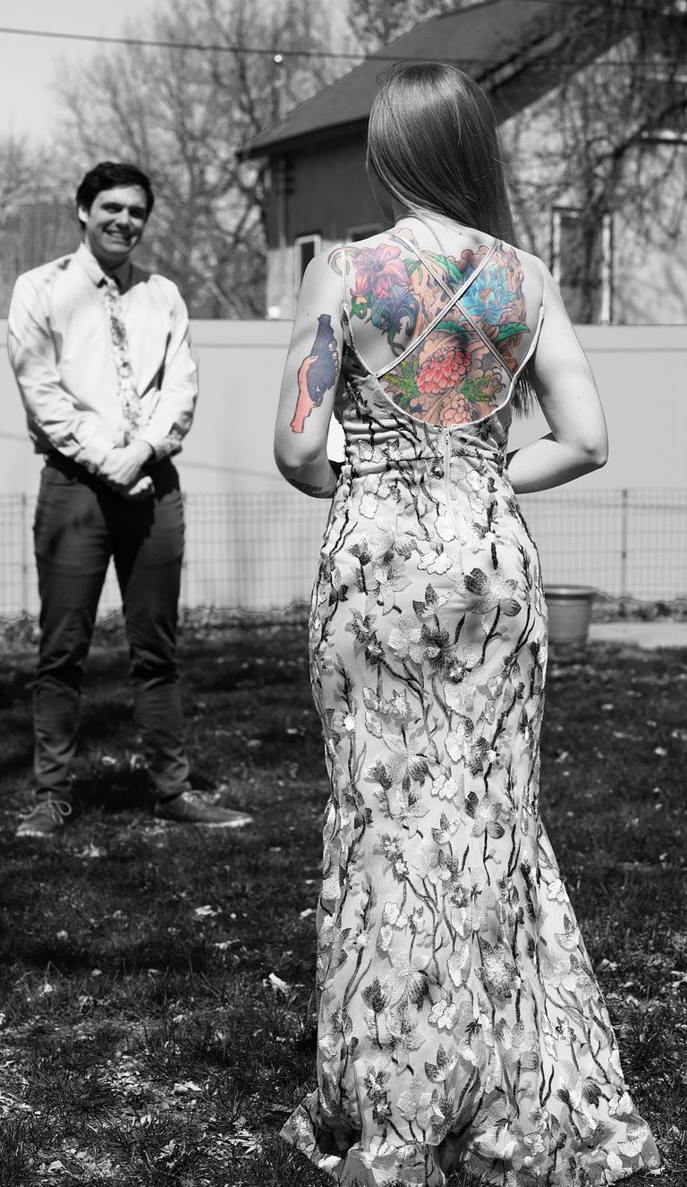 a woman with tattoos on her back looking at a man in front of her