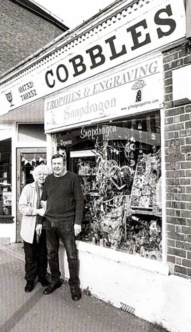 a man and woman standing in front of a store