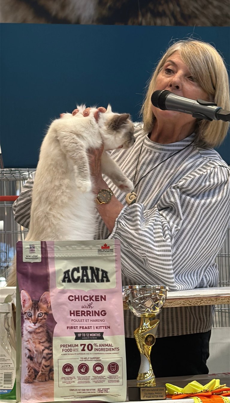 a woman is holding a cat in front of a microphone