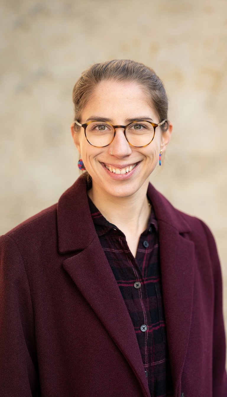 a woman in glasses and a red jacket