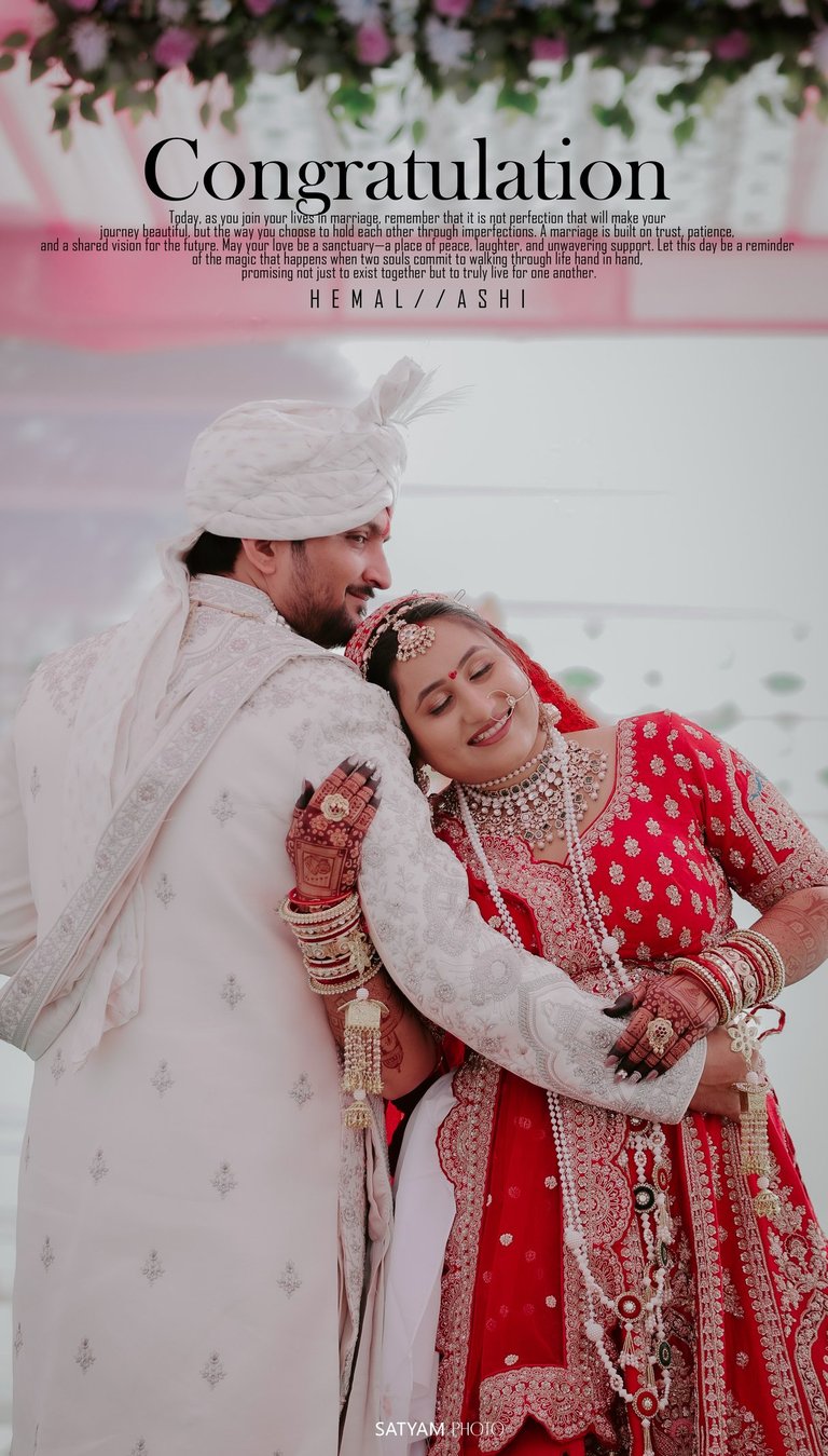 Romantic Indian wedding couple pose, bride in red lehenga leaning on groom in white sherwani. RD