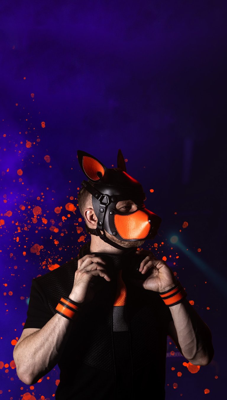 Man posing in a pup mask.