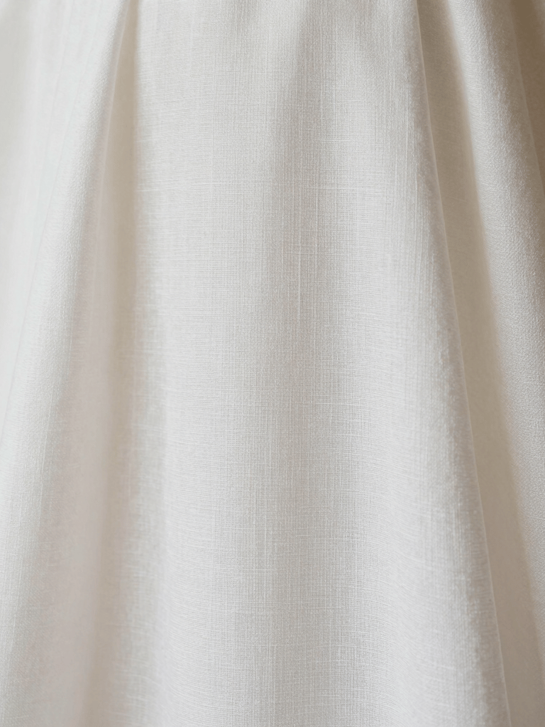 Macro photography of an elegant baptismal gown made of fine white linen, soft textures, minimalist and clean composition, European / Spanish traditional aesthetic, bright off-white tones.
