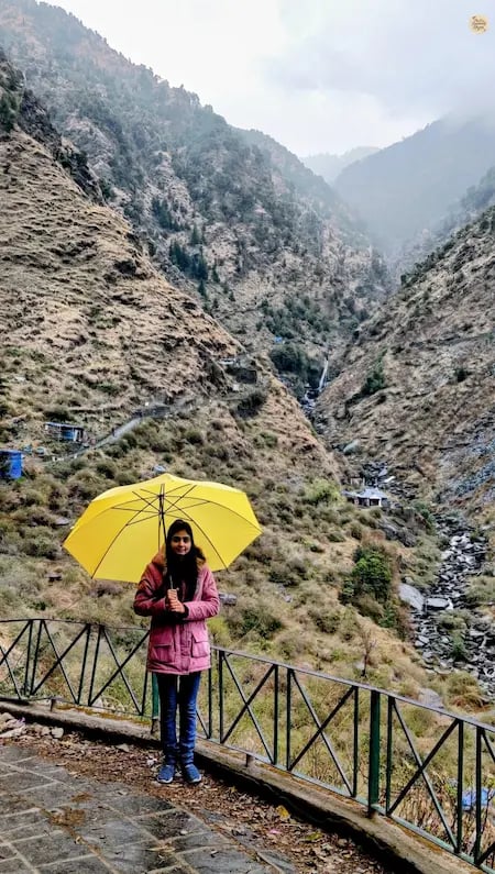 Scenic walking trail leading to Bhagsunag Waterfall in McLeod Ganj, surrounded by forested hills and mountain views.