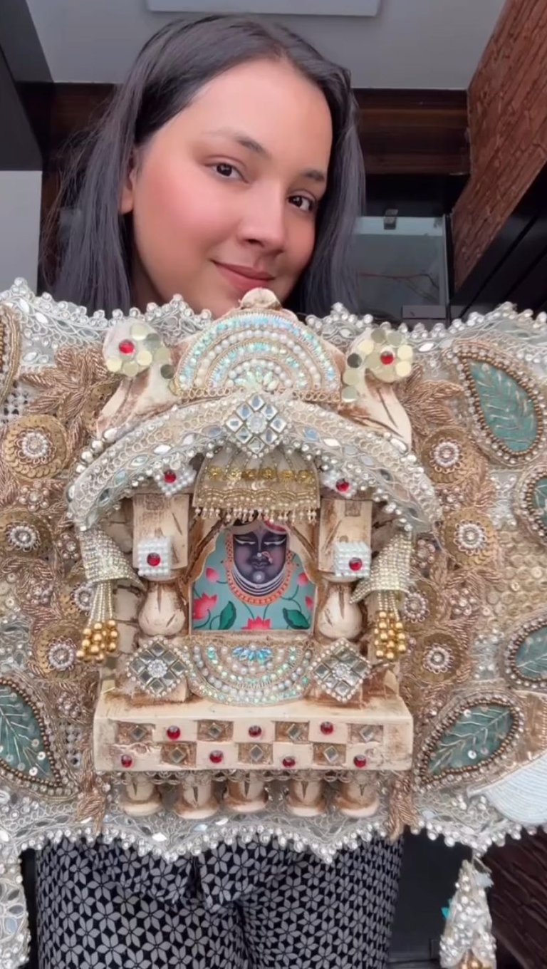 a woman holding a decorative piece of art