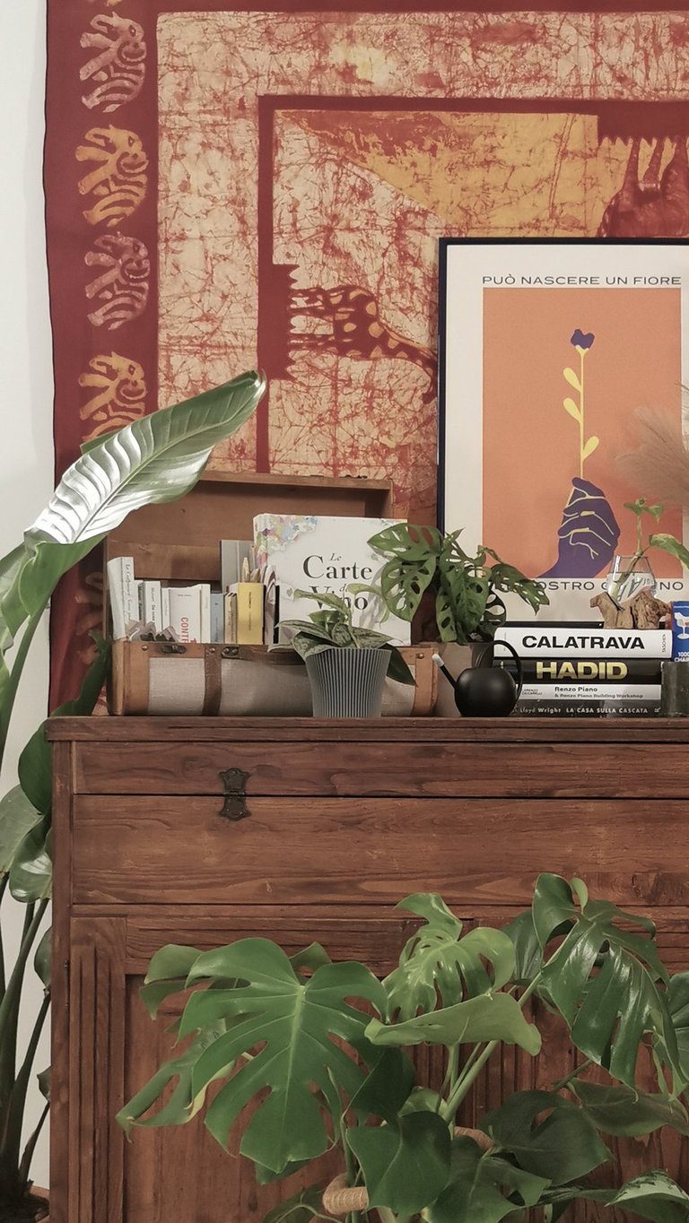 a dresser with a large tapestry hanging on a wall
