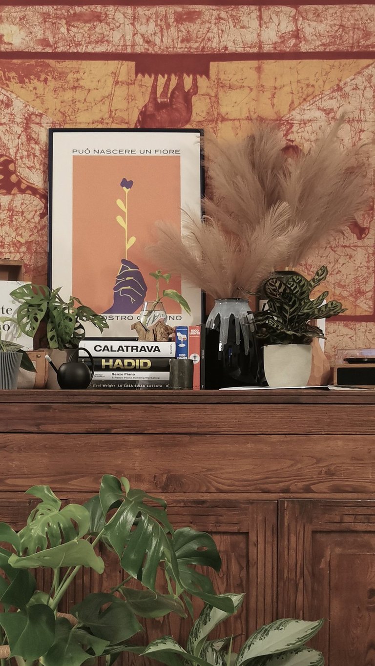 a dresser with a large tapestry hanging on a wall