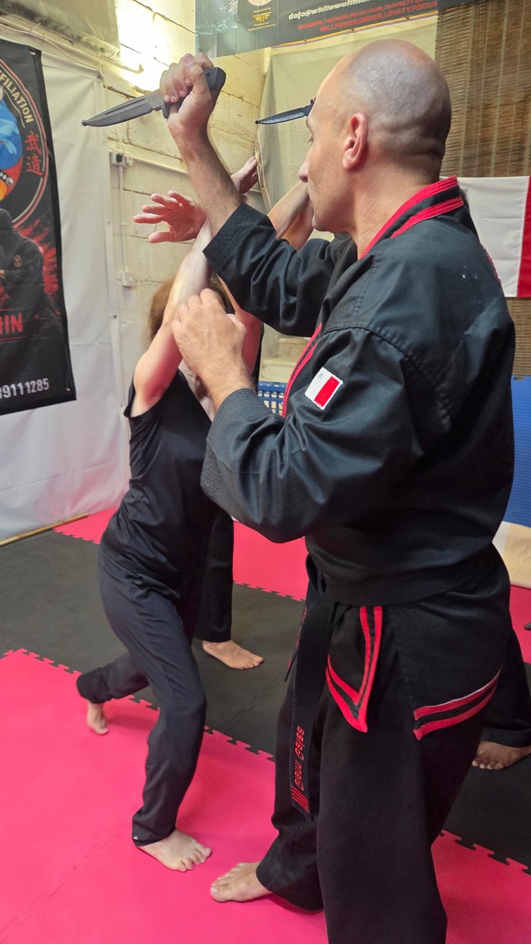 A martial arts instructor demonstrates a knife defense technique during a self-defense class.