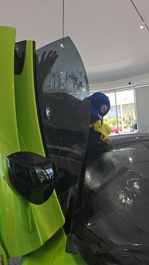 bluemax Technician intalling window film on a mclaren windows