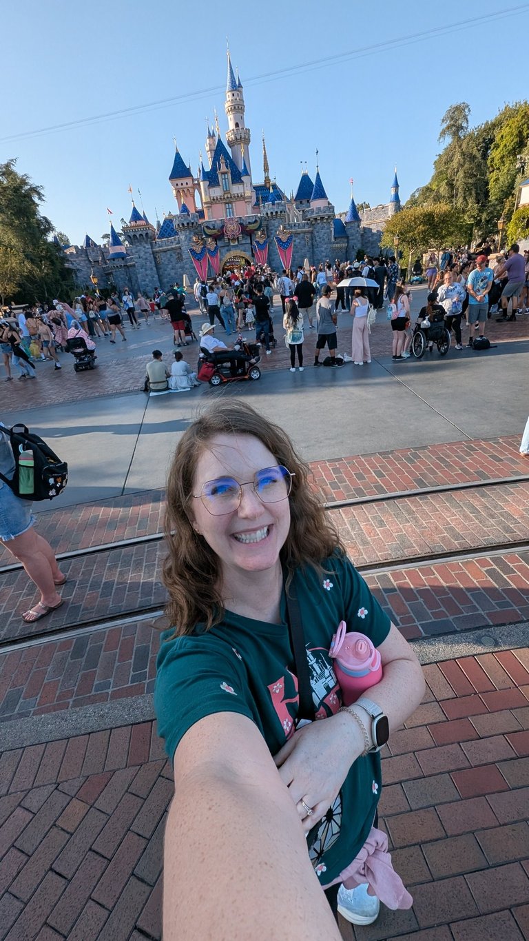 Katie Matzenbacher, standing in front of Sleeping Beauty's castle at Disneyland in California