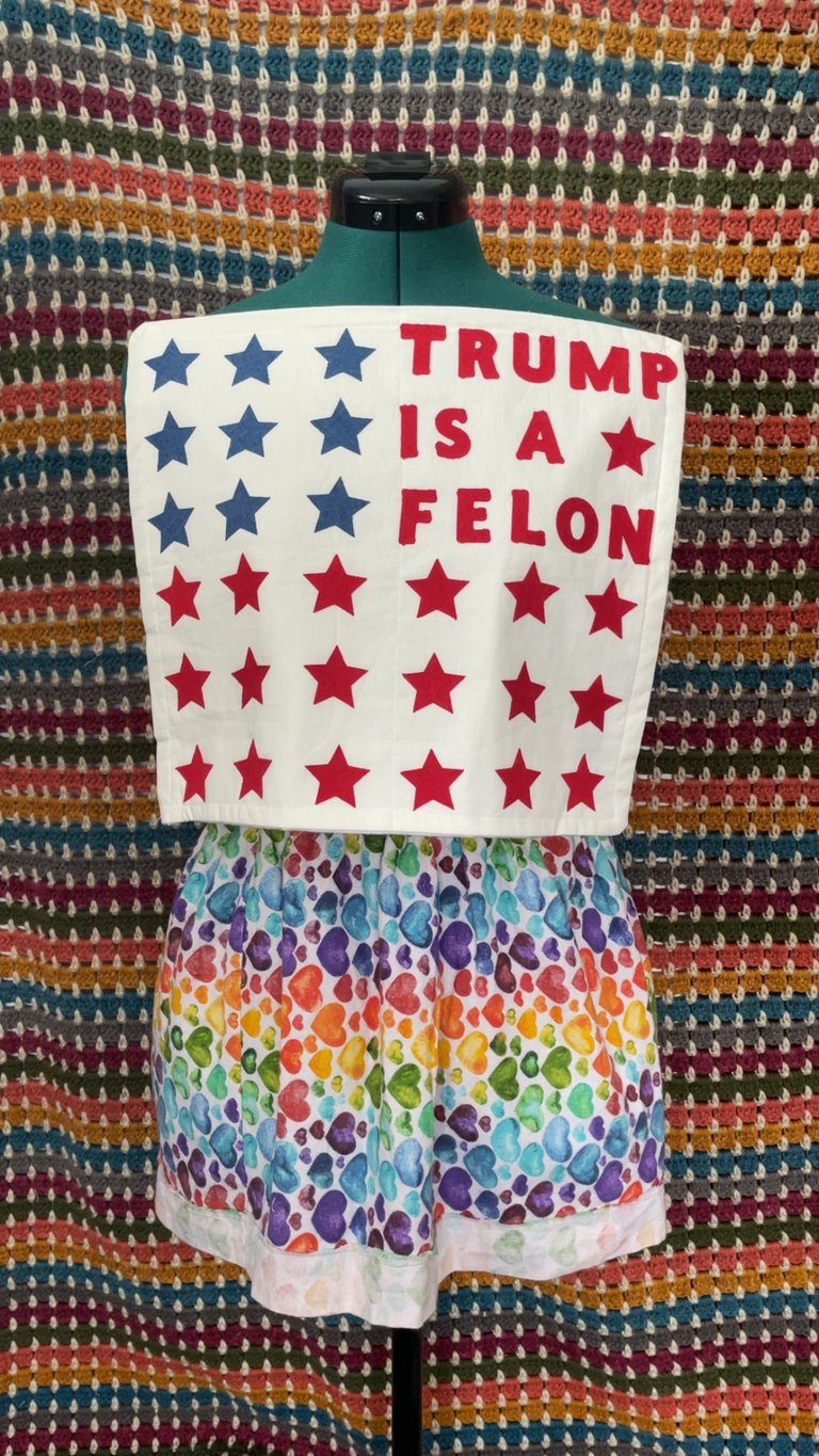 Trump is a Felon flag: white square with red and blue stars and red TRUMP IS A FELON letters