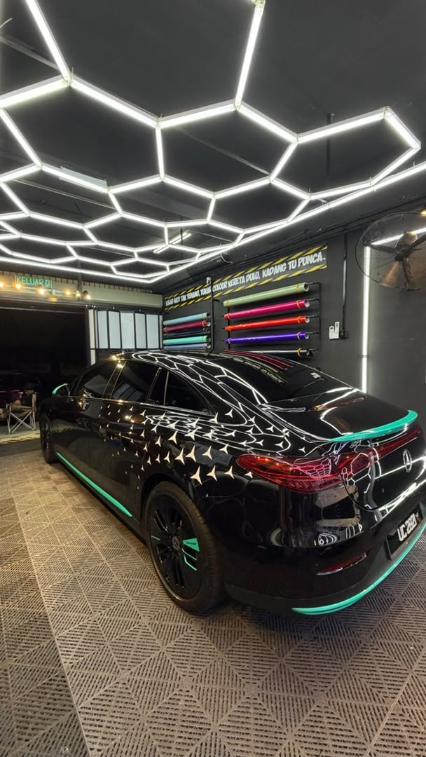 Mercedes sedan with custom black star pattern and teal accent wrap