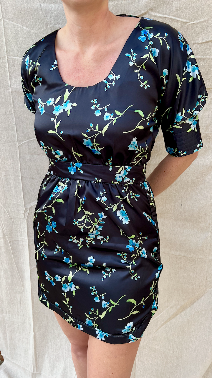 The front of a black satin cocktail dress with blue printed flowers