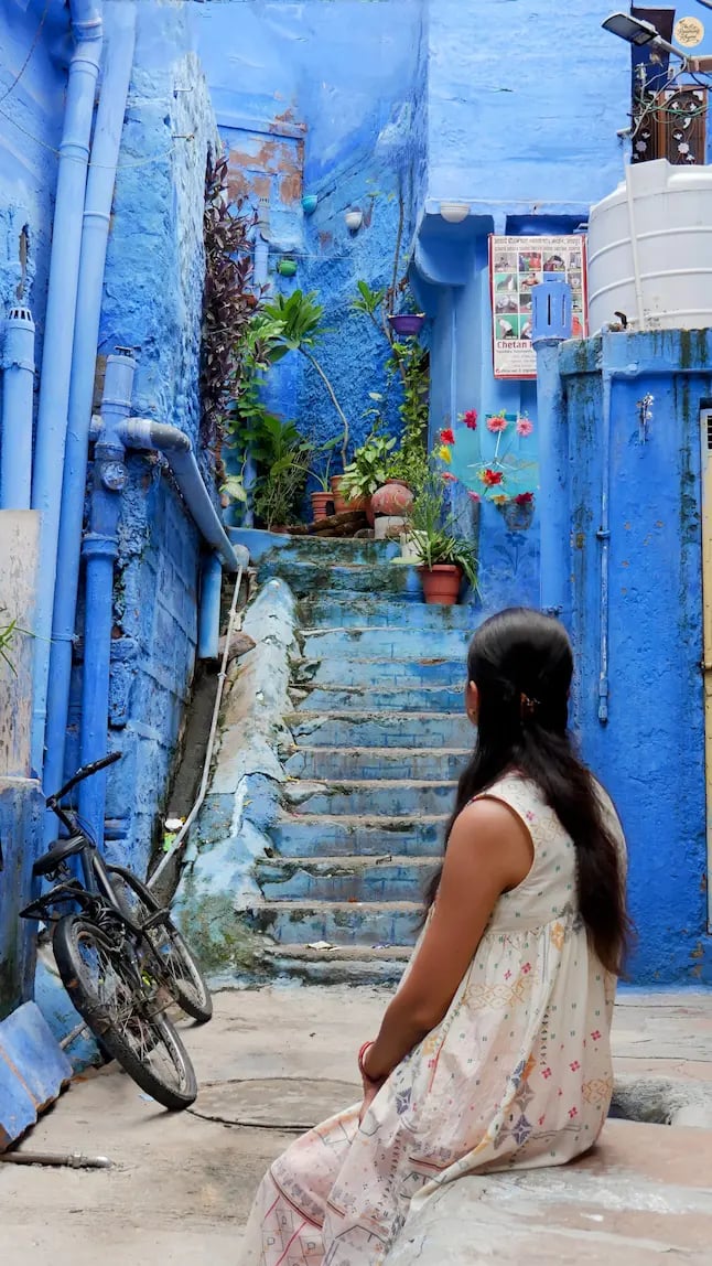 Serene blue lane in Jodhpur, where travelers can pause to relax and enjoy the city’s painted beauty.