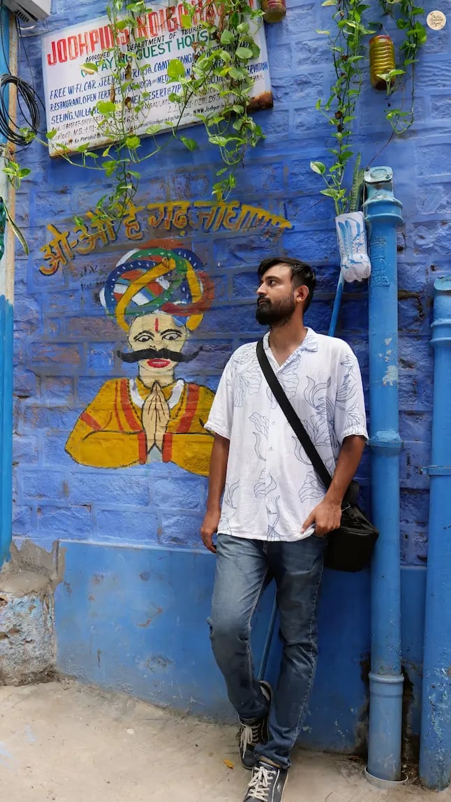 Colorful mural of a Rajasthani man painted on a blue wall in Jodhpur, reflecting local culture and street art.
