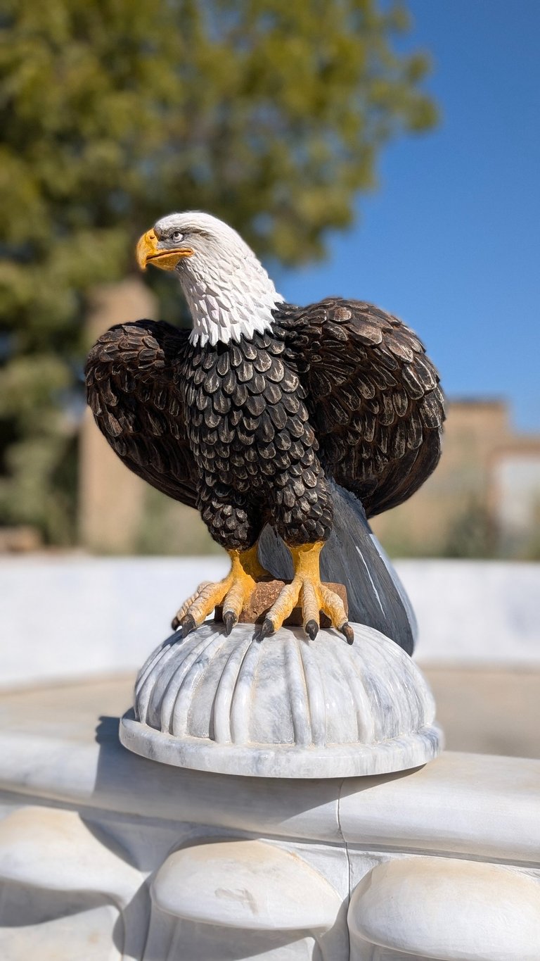 a statue of a bald eagle sitting on a pedestal