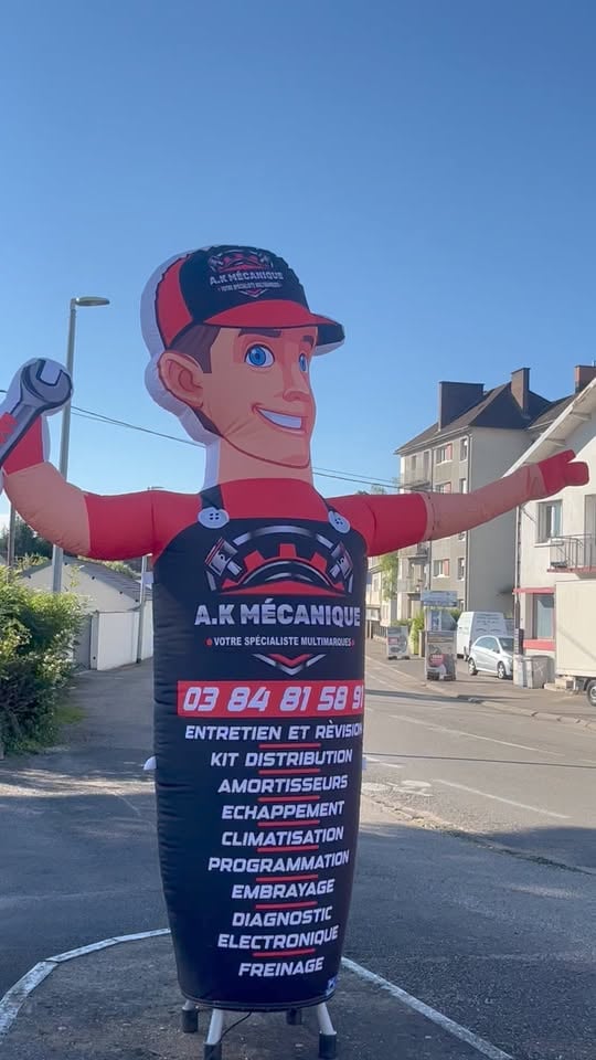 a man in a red and black suit and a large inflatable sign
