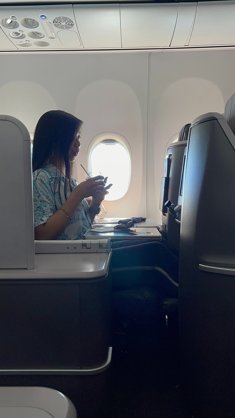 a lady drinking on a business class suite on singapore airlines