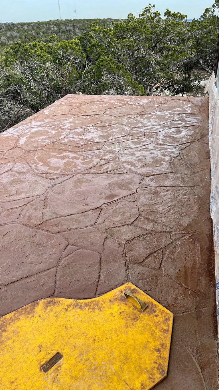 Colored and stamped concrete balcony after waterproofing deck.