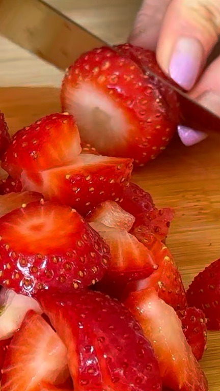 Taglia le fragole a piccoli pezzi