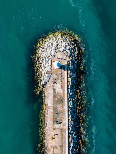 outcropped peninsula seawall with lighthouse aerial view