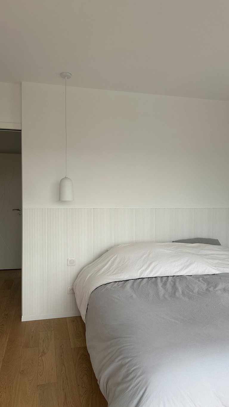a white bed and a white lamp