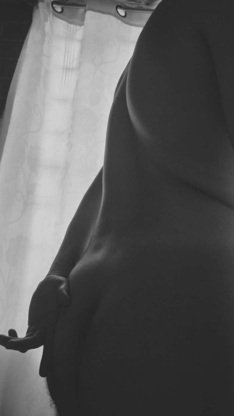 Hombre en blanco y negro que resalta las curvas del cuerpo en contraluz