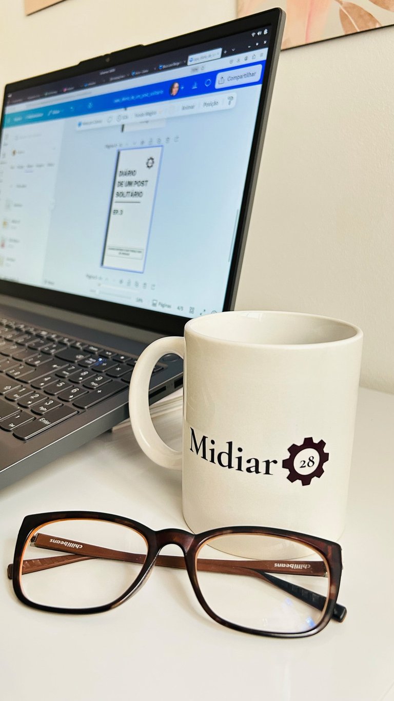 um-óculos-de-grau-proximo-a-uma-caneca-escrito-midiar-28-e-a-tela-de-um-computador