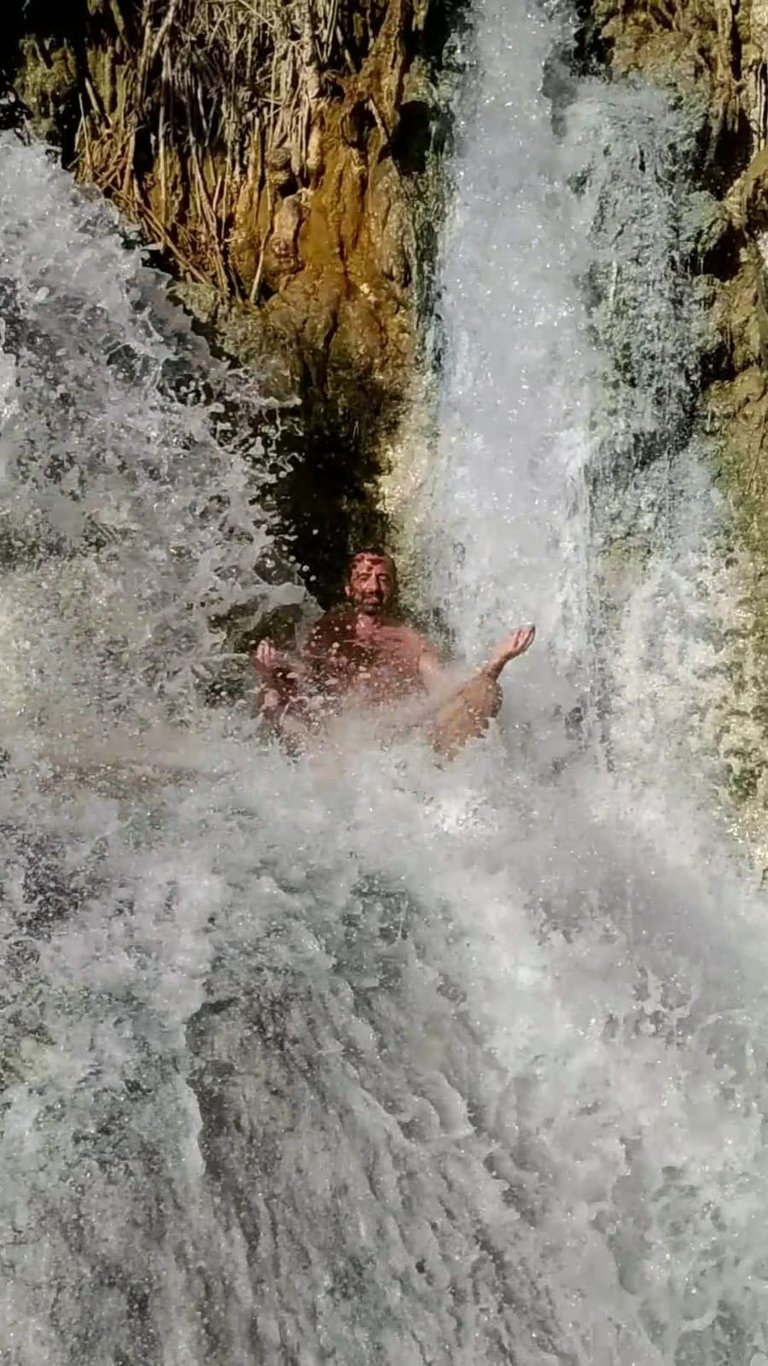 a man meditating in a waterfall in the middle of a waterfall