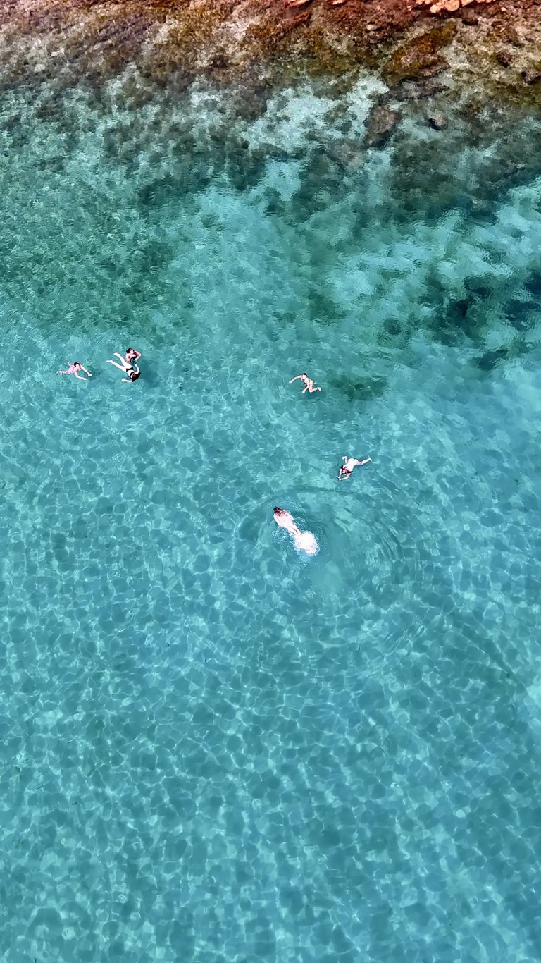 Aerial view of girls swimming and snorkeling in a bay near Milna on Brac during a private boat tour from Split, Croatia