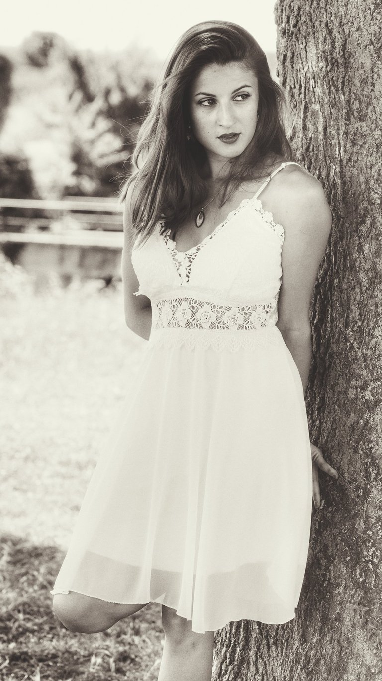 Une jeune belle femme adossée à un arbre